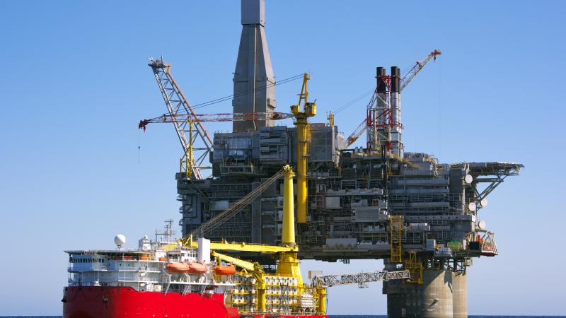 A boat approaches an oil rig