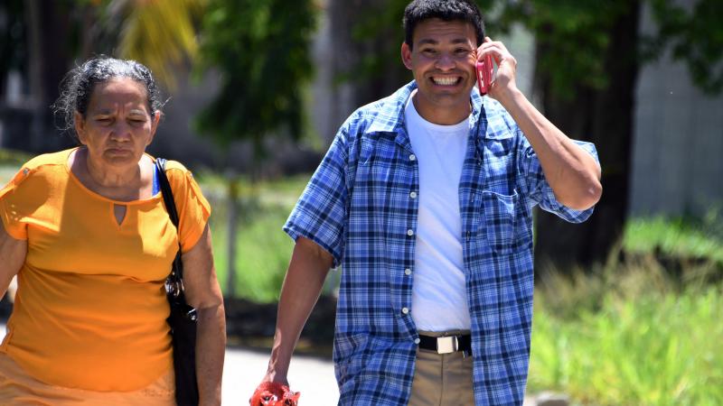 Honduran immigrant talks on cell phone, 2018