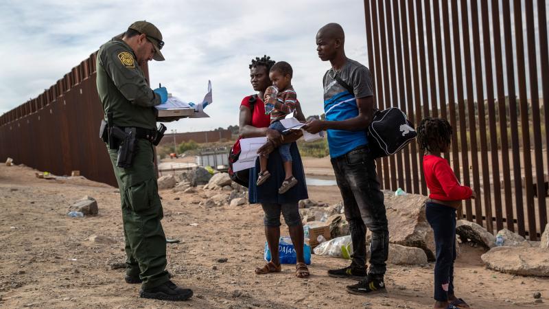 Haitian migrant family with Border Patrol agent, Yuma, Ariz., Dec. 7, 2021