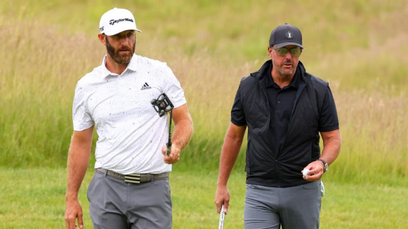Dustin Johnson of 4 Aces GC greets Phil Mickelson of Hy Flyers GC look on on the 4th green during day one of the LIV Golf Invitationa