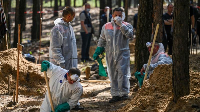 Forensic technicians at mass grave, Ukraine, Sept. 18, 2022