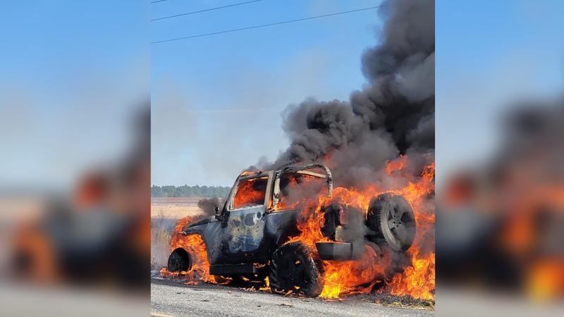 A shot of the mail truck up in flames