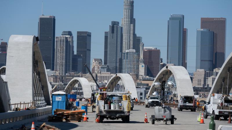 Supply trucks crowd the deck during the construction of the new 6th Street Bridge with a view of the downtown skyline on March 8, 2022 in Los Angeles, California.