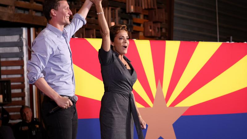 Arizona Republican gubernatorial candidate Kari Lake (R) and Arizona U.S. Senate candidate Blake Masters raise their arms at a campaign rally on November 05, 2022 in Queen Creek, Arizona.