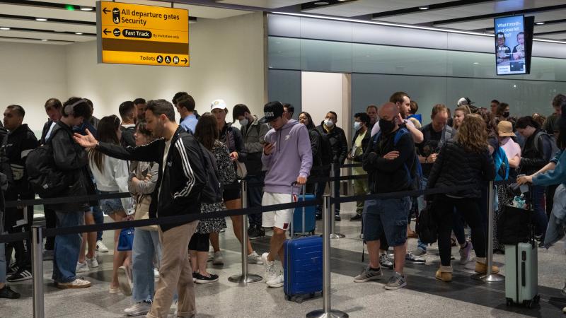 Travellers wait in a long queue to pass through the security check at Heathrow on June 1, 2022 in London, England