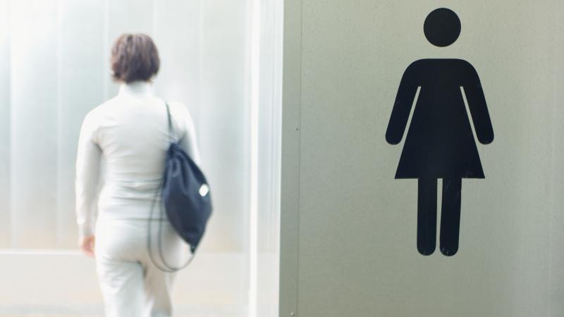 Woman enters bathroom/locker room, stock photo