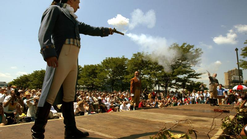 Antonio Burr (L), a descendant of Aaron Burr's cousin, fires with Douglas Hamilton (R), a fiith-great-grandson of Alexander Hamilton, during a reenactment marking the 200th anniversary of the Alexander Hamilton - Aaron Burr duel July 11, 2004 in Weehawken, New Jersey.