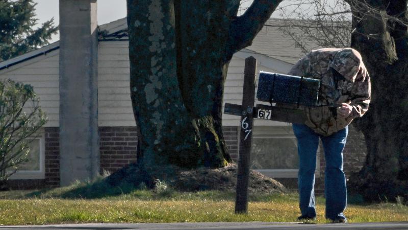 A local man checking his mailbox