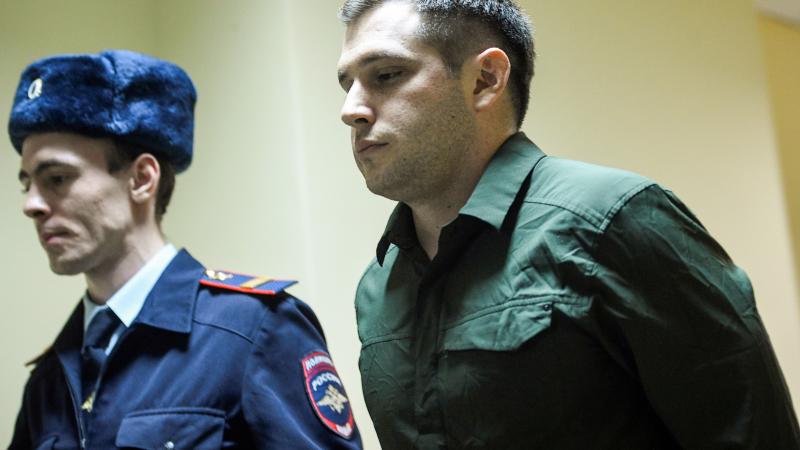 Former Marine Trevor Reed being escorted by Russian police