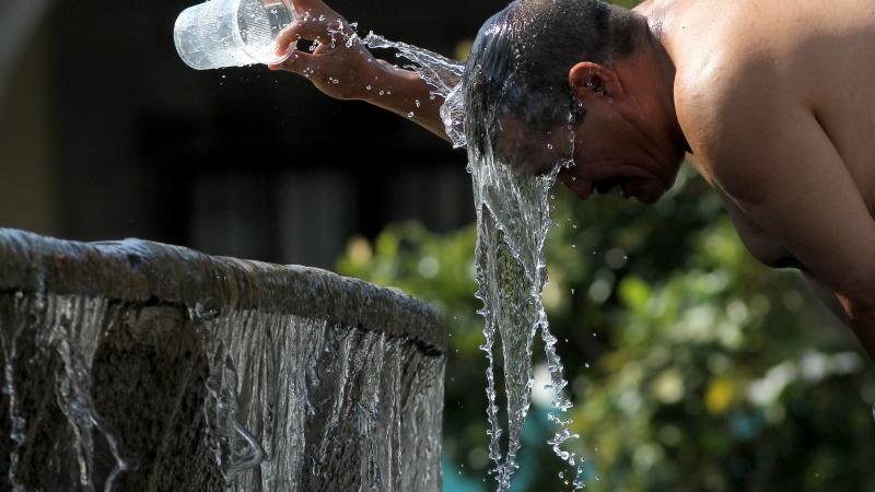 Man cools down with water in heat, Guadalajara, Mexico, June 12, 2023