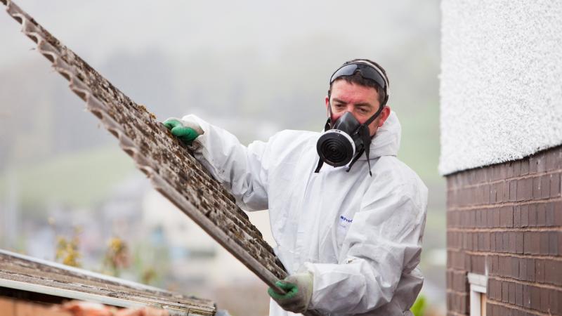 Asbestos removal in hazmat suit, gas mask, Cumbria, U.K., May 5, 2010