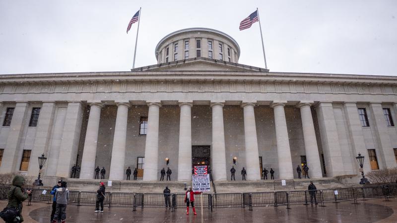 A Trump supporter holds up a sign during an armed protest at the Ohio Statehouse ahead of the inauguration of President-elect Joe Biden in the wake of the Coronavirus COVID-19 pandemic, Sunday, January 17th, 2021, in Columbus, Ohio, United States. 