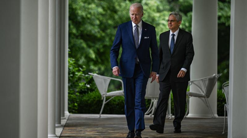 US President Joe Biden (L) and US Attorney General Merrick Garland (R) walk into the Rose Garden from the Oval Office for an event on the Presidents American Rescue Plan at the White House in Washington, DC, on May 13, 2022.