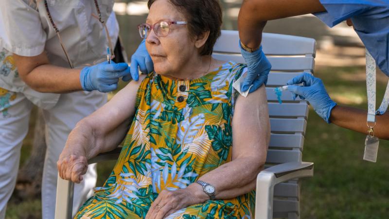 Elderly woman receives COVID vaccine
