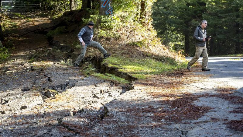 Spencer Watkins and John Oswald, engineering geologists with California Geological Survey, look over earthquake damage on Shively Road outside Scotia, Calif., on Friday, December 6, 2024, that formed after a 7.0 earthquake hit off the coast near Eureka the day before