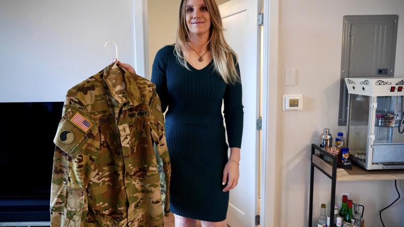 Jo Ellis holds one of her firearms in her apartment in Richmond, Virginia, on February 12, 2025. Gingerly placing a gun on her kitchen counter, American trans pilot Jo Ellis said she no longer leaves her apartment without a firearm after false online claims about her involvement in a fatal air crash triggered a deluge of threats.