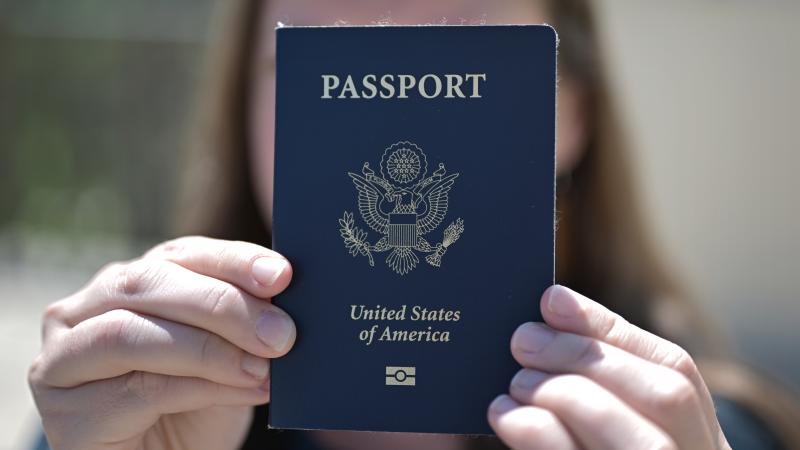 Woman holding up U.S. passport in front of her face