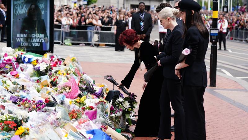 Sharon Osbourne, with family members, lays flowers at the Black Sabbath Bridge bench on Broad Street in Birmingham in memory of Black Sabbath frontman Ozzy Osbourne, as his body is brought back to his home city for a procession following his death last week aged 76. 