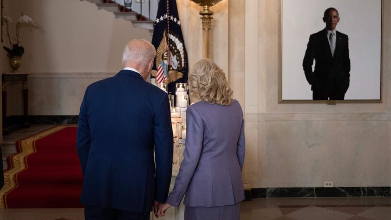 A portrait of former US President Barack Obama is seen as US President Joe Biden and US first lady Jill Biden look at candles during an event in the at the Grand Staircase of the White House to mark the one year anniversary of the Uvalde school mass shooting May 24, 2023, in Washington, DC.