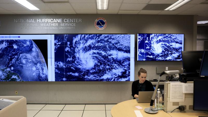 Lisa Bucci, Hurricane Specialist, works near screens showing Tropical Storm Erin as they continue to track its progress on August 13, 2025 at the National Hurricane Center in Miami, Florida. 