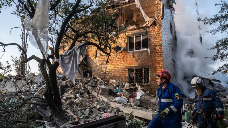Ukrainian emergency services are seen at the site of an overnight air strike on civilian apartment building.