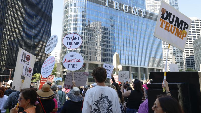 Protesters hold signs reading "Dump Trump" during a rally outside Trump Tower on Labor Day in Chicago, Illinois, September 1, 2025