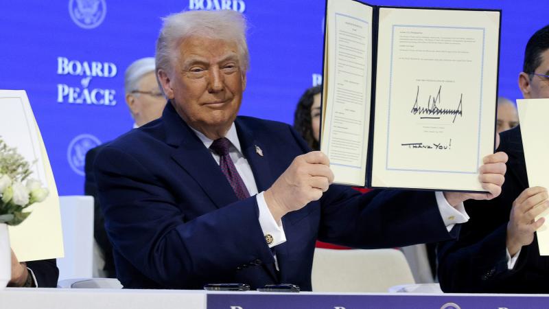 U.S. President Donald Trump holds up his signature on the founding charter during a signing ceremony for the “Board of Peace” at the World Economic Forum (WEF) on January 22, 2026 in Davos, Switzerland.