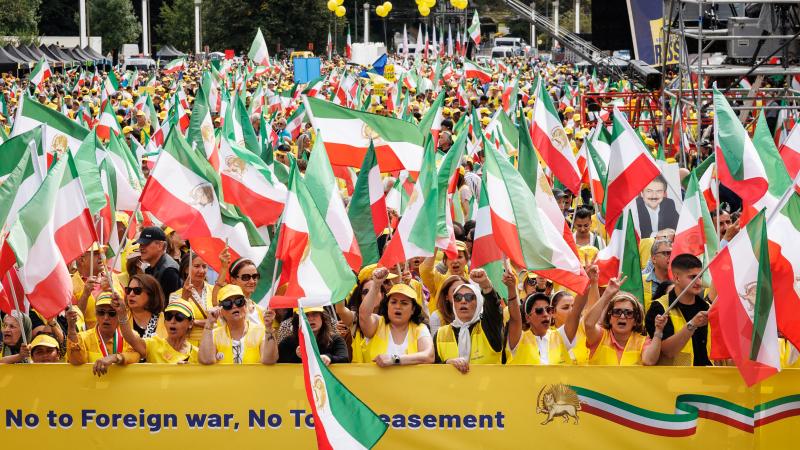 Protesters hold Iranian flags during a demonstration against the Iranian regime in Brussels on September 6, 2025. The protest is called by the opposition organization The National Council of Resistance of Iran (NCRI) and ask for the implementation of UN Security Council resolutions against the Iranian regime. 