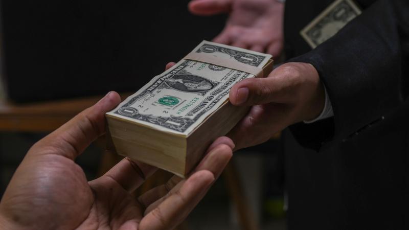Businessmen secretly passing money - bribery and corruption concepts