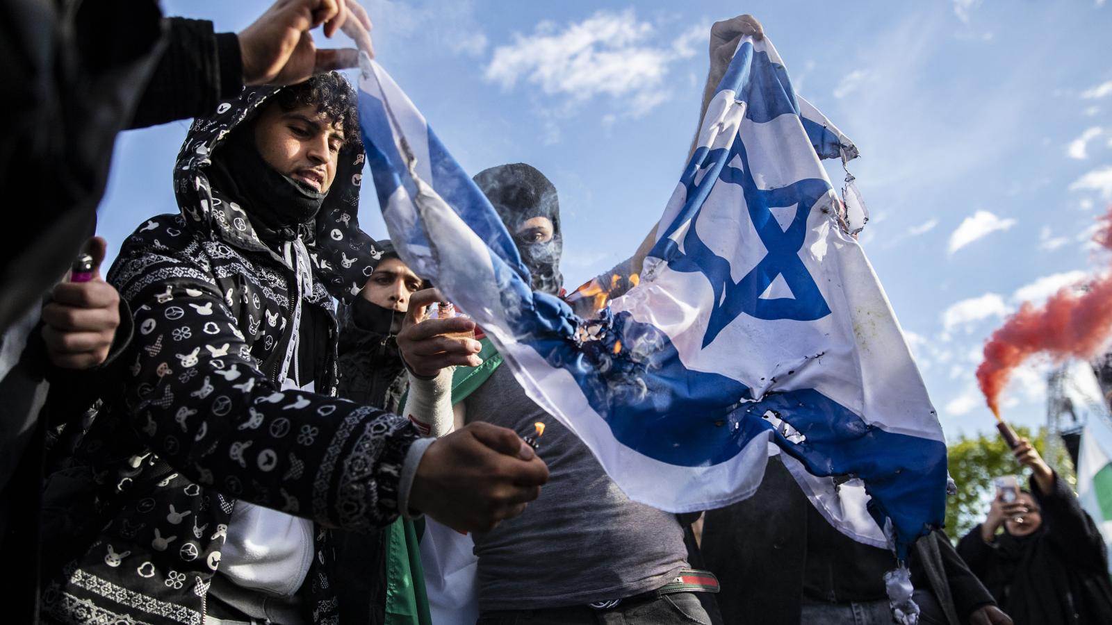 Palestinian supporters seen burning a flag of Israel at Hyde park during a demonstration against state violence.