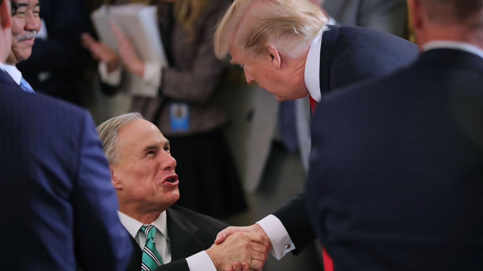 Then-President Trump greets Texas Gov. Greg Abbott in February 2018