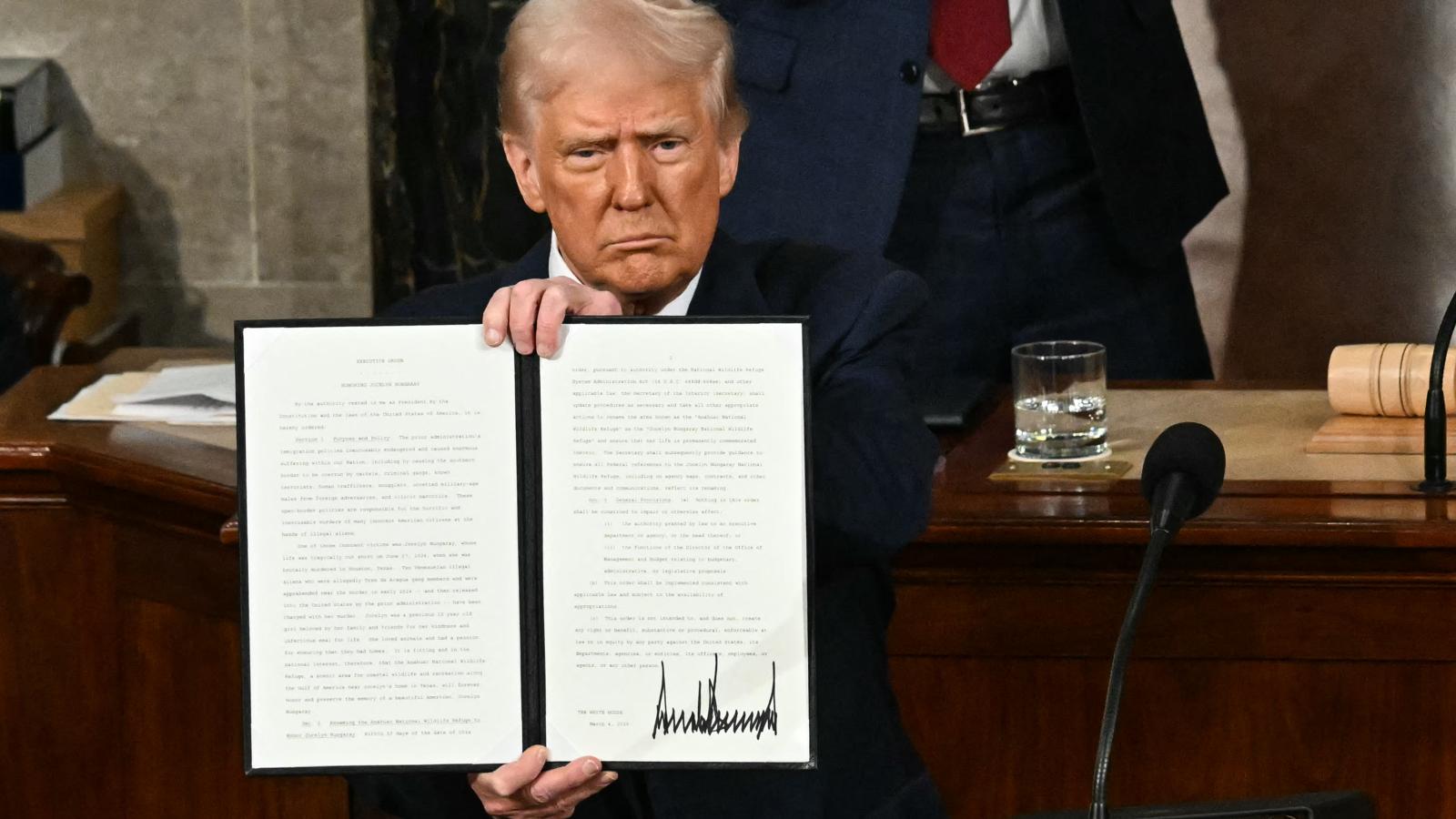 US President Donald Trump holds up an executive order that renames a wildlife sanctuary in honor of the late Jocelyn Nungaray, a 12 year-old girl who was murdered by two undocumented migrants, during an address to a joint session of Congress at the US Capitol in Washington, DC, on March 4, 2025.