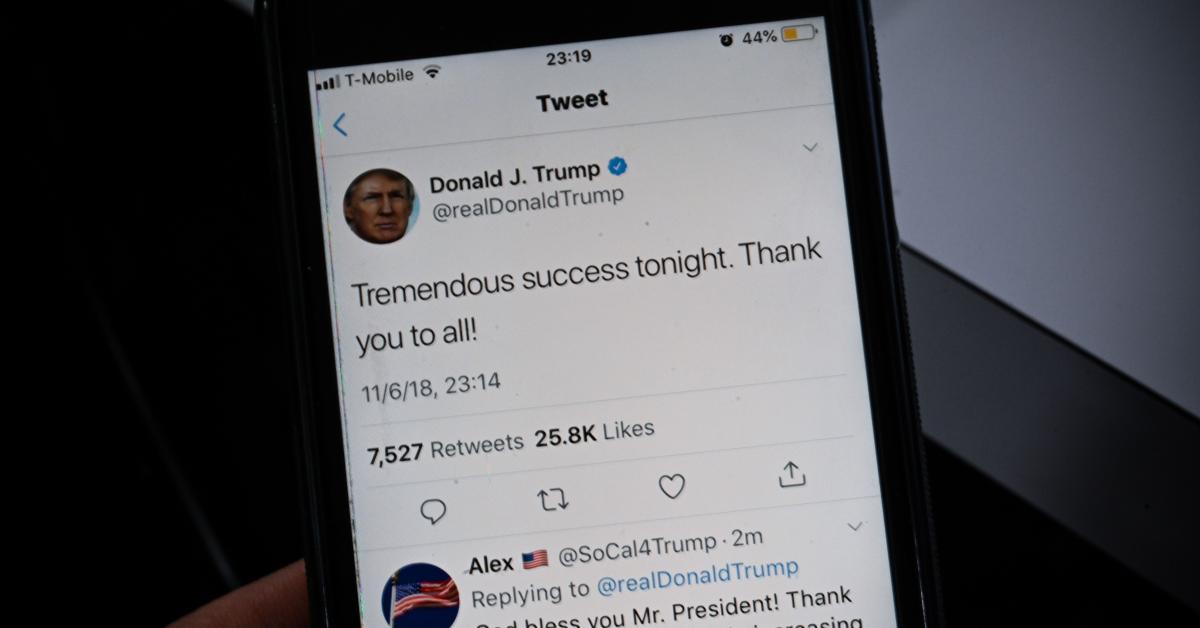 A smartphone shows a tweet by President Trump | (Photo credit: ERIC BARADAT/AFP via Getty Images)