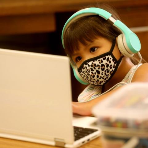 A student participates in a Zoom lesson from classroom.