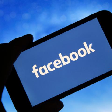 Photo illustration of Facebook logo seen on screen of phone in January 2019 in France