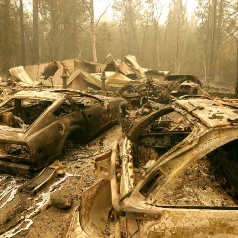 Burned out cars sit in front of a home that was destroyed by the Dixie Fire on July 26, 2021 in Indian Falls, California.